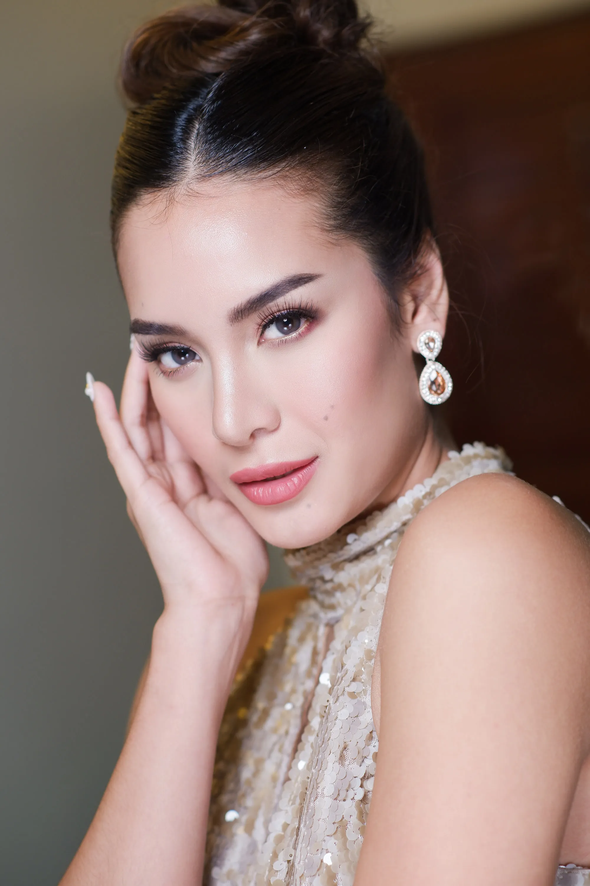 Soft glam with a warm shimmer eye and a rose lip, worn with a high bun, chandelier earrings and a gold sequinned high neckline.