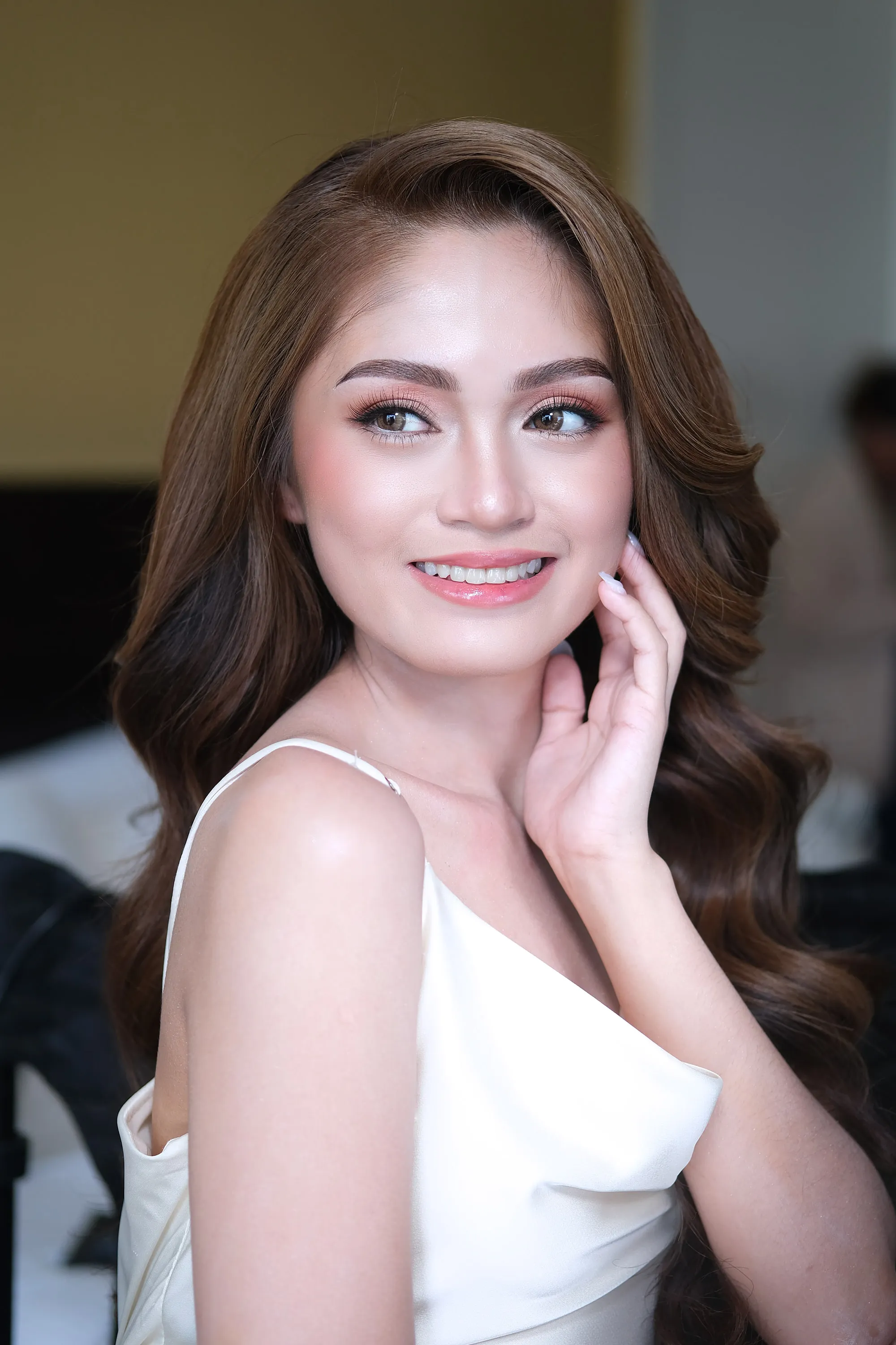 Bridal make-up with mauve shadow and a glossy pink lip, worn with loose waves and a white satin slip.