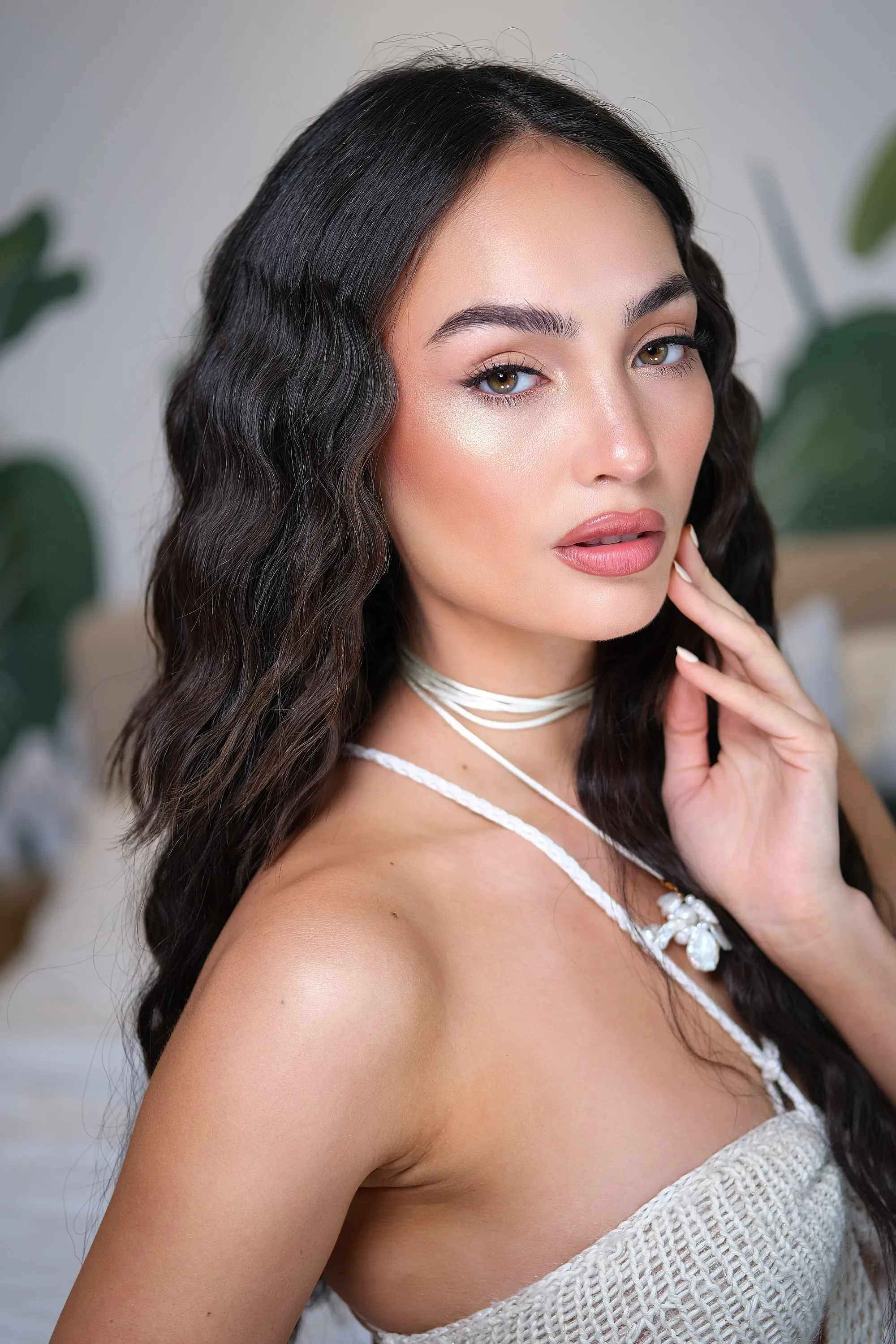 The same high-shine editorial look with the hand raised to the jaw and the waves pushed back.