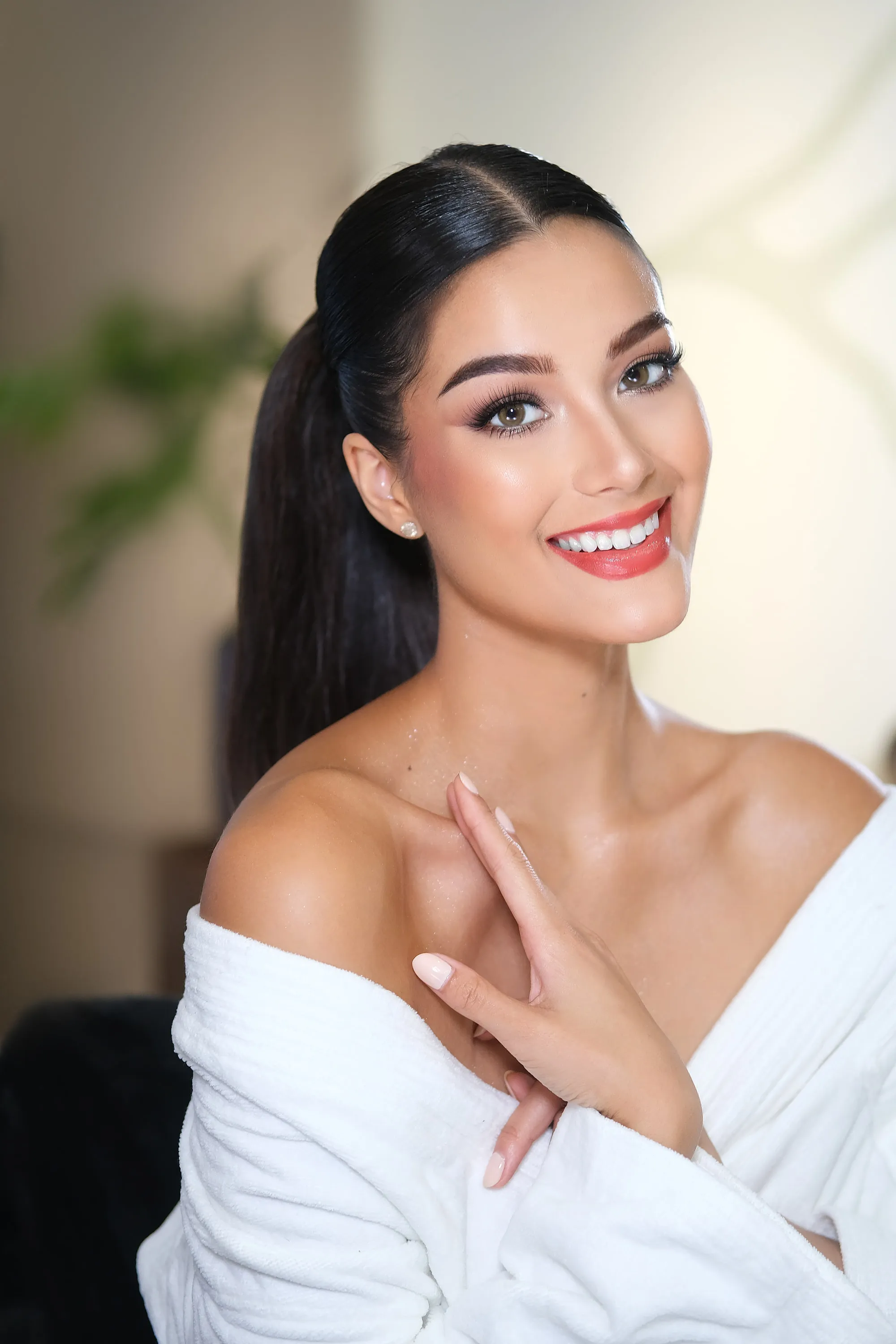 The same preparation look, smiling, with the highlight on the cheekbone and the hair pushed off the shoulder.